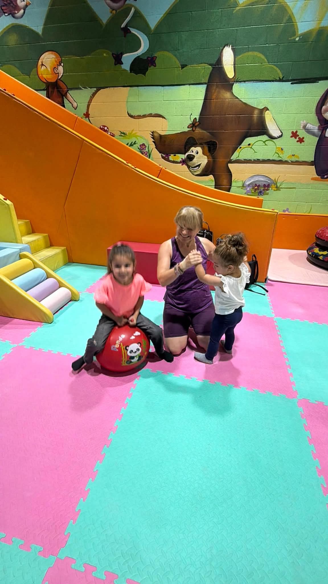 Children and an adult share a moment during an inclusive play and movement class.